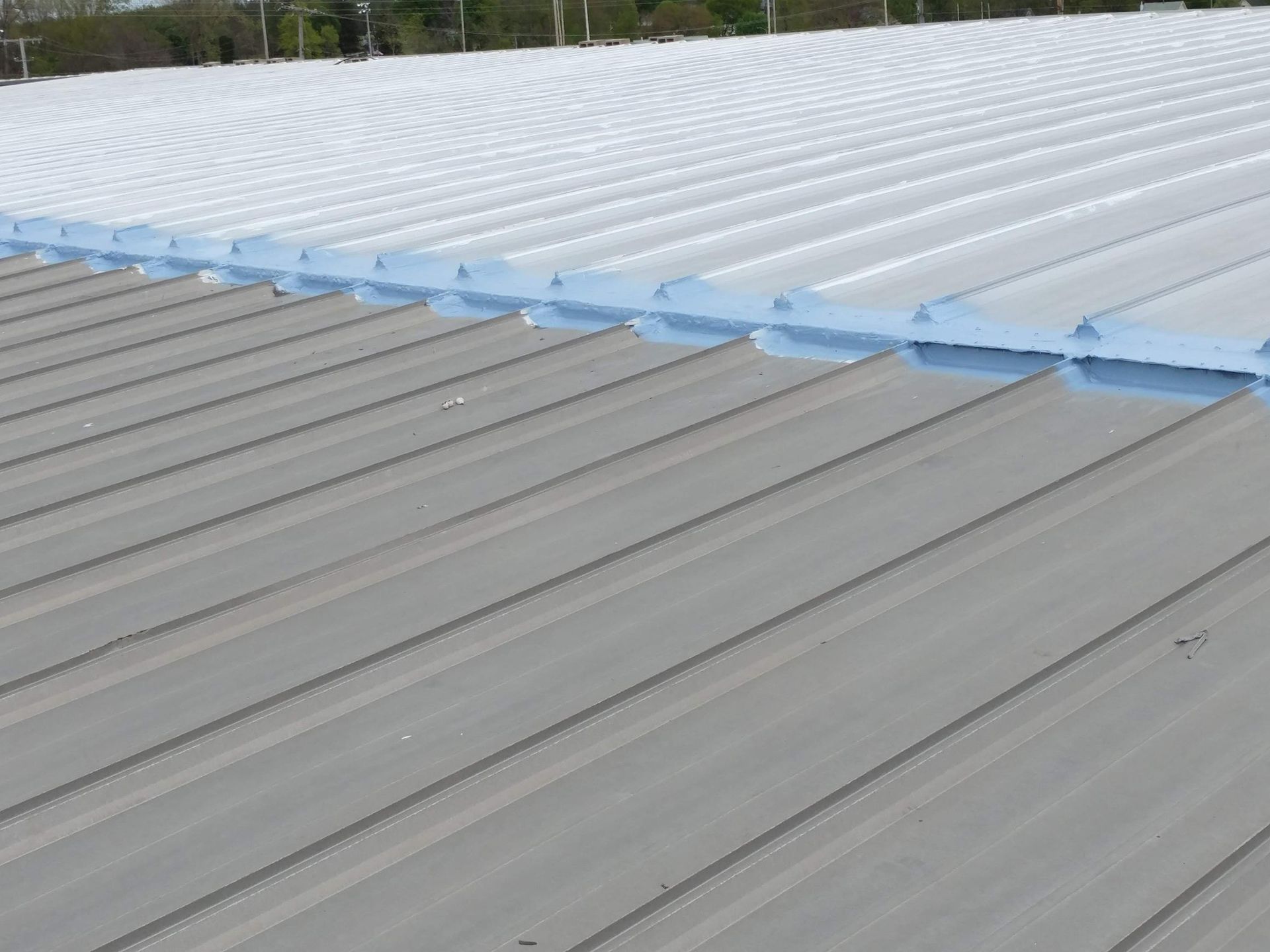 A close up of a metal roof with white paint on it