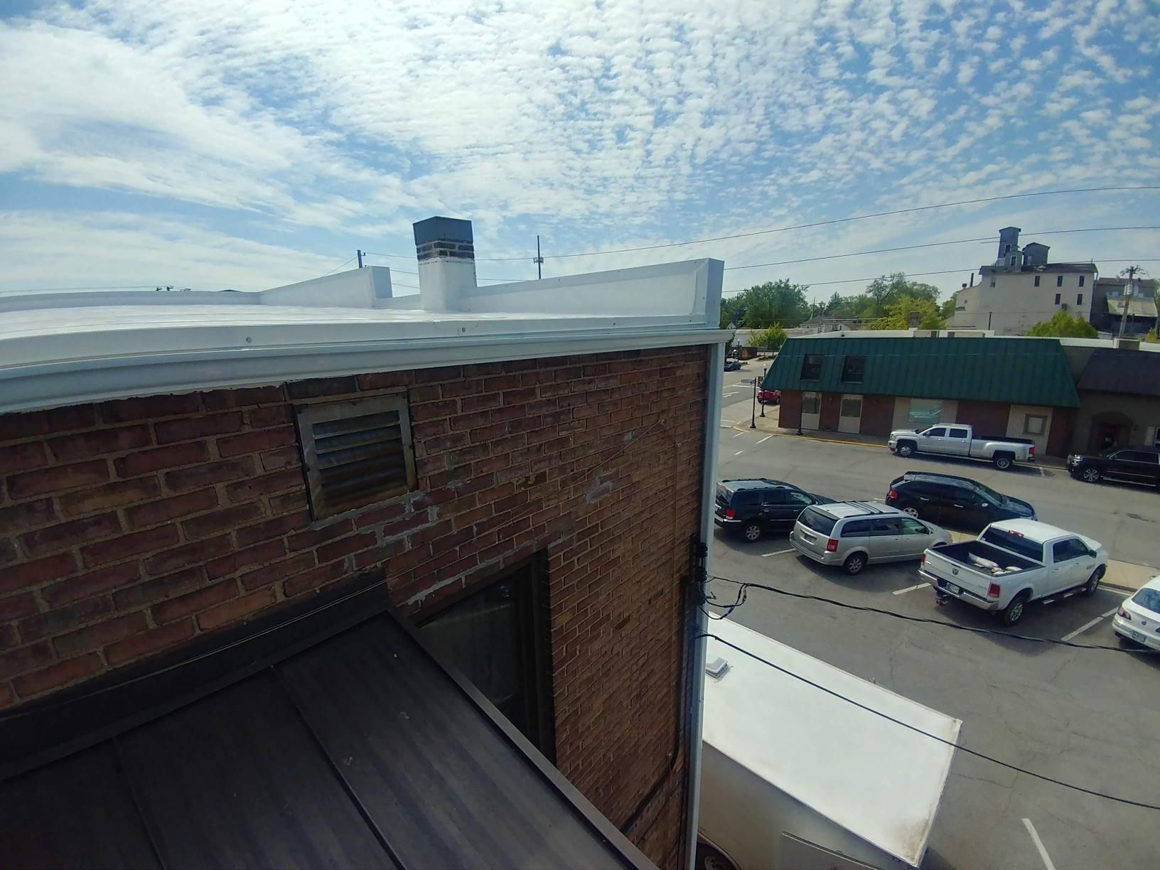 A brick building with a white truck parked in front of it.