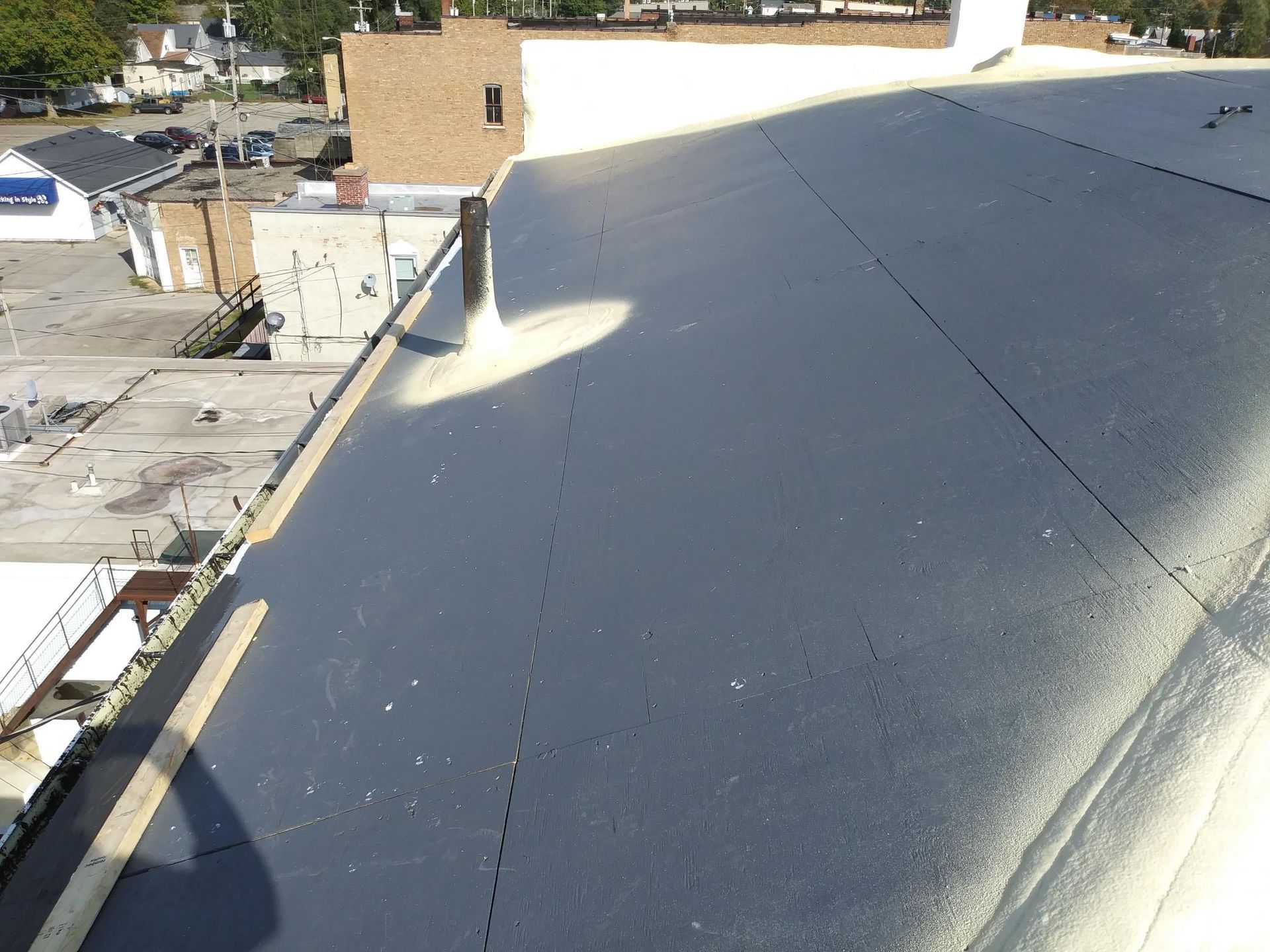 A black roof with a chimney on top of it