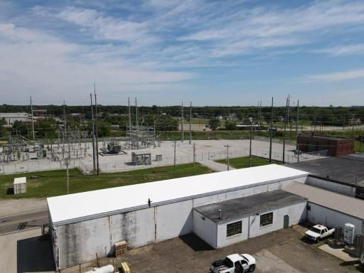 An aerial view of a building with a white roof and a truck parked in front of it.