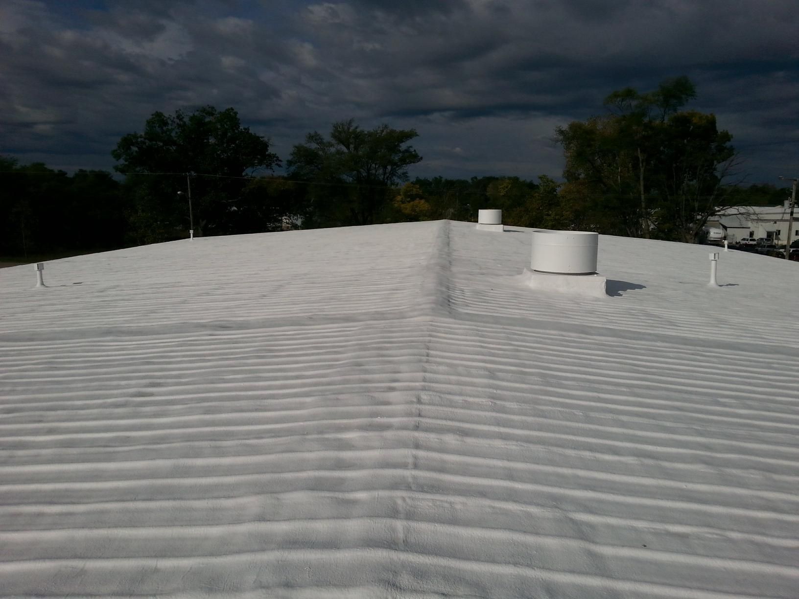A white roof with a few trees in the background