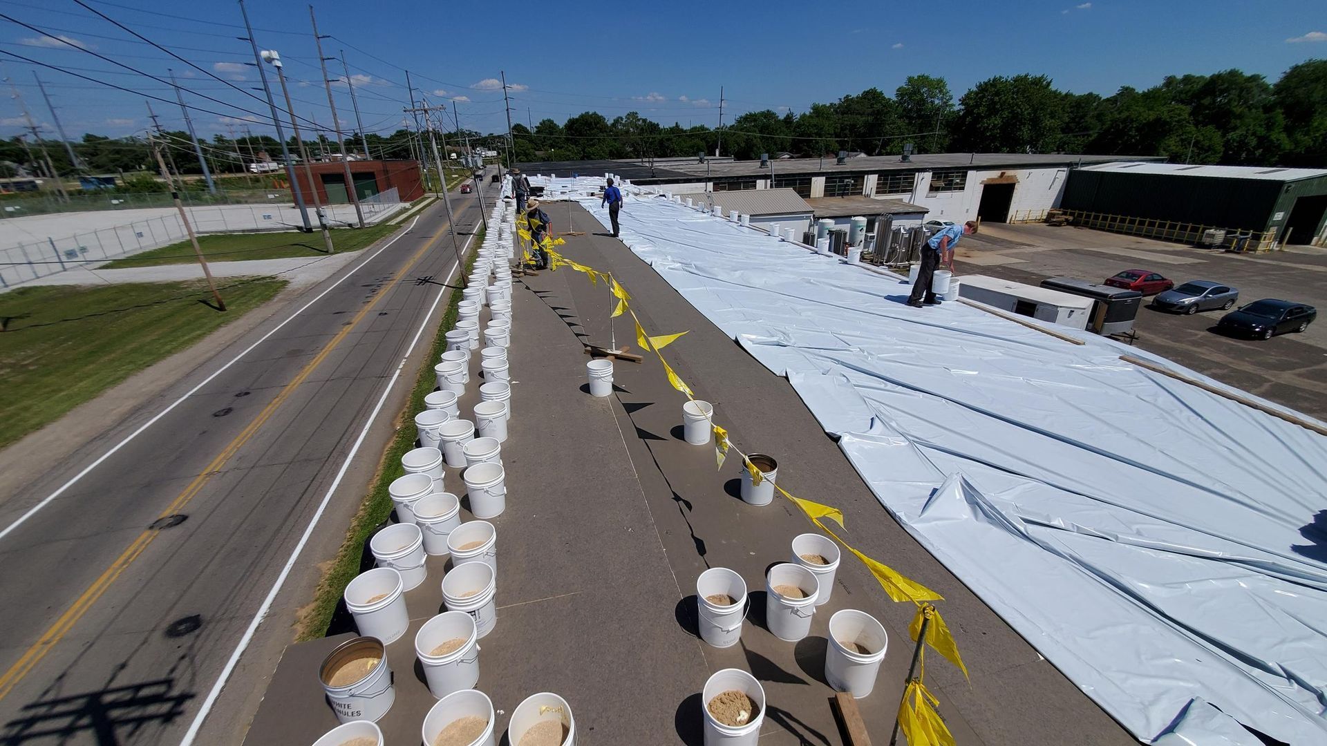 A row of buckets are lined up on the side of a road.