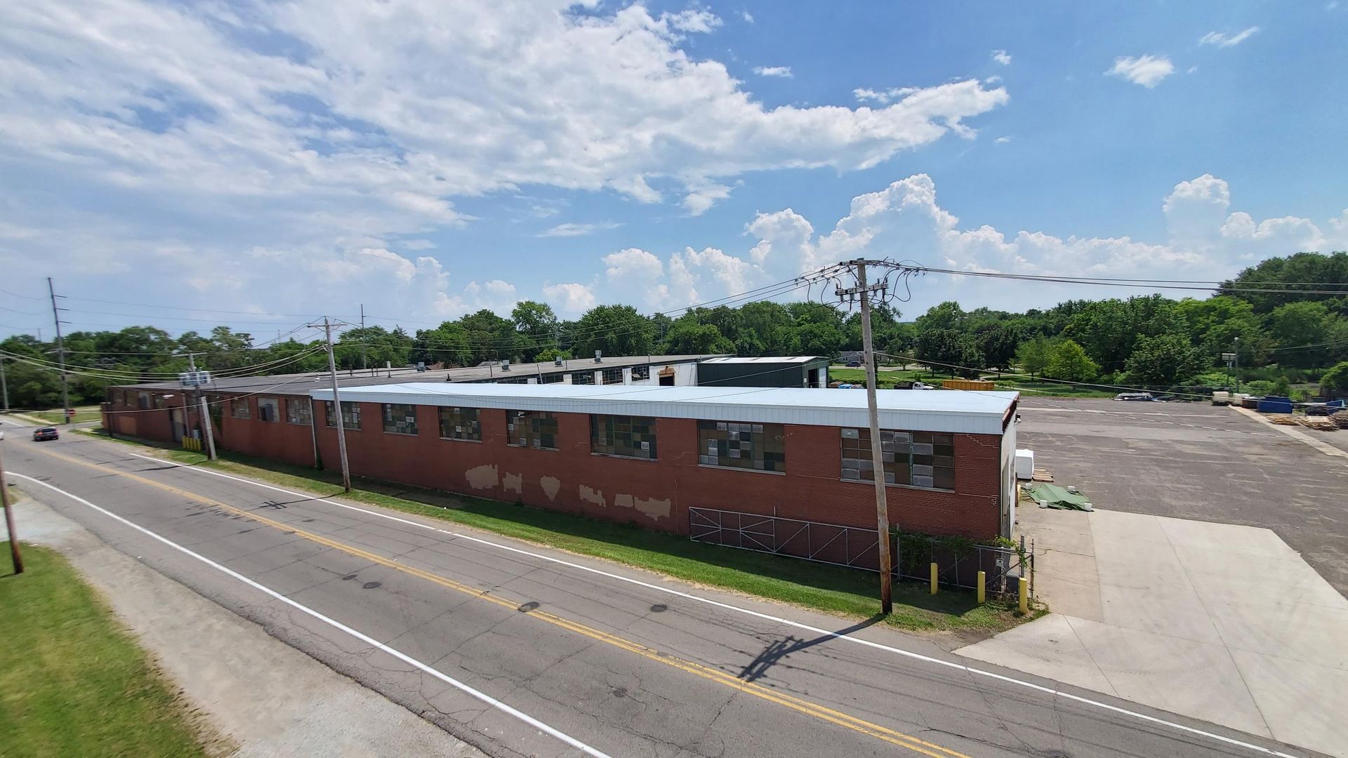 An aerial view of a brick building next to a road.