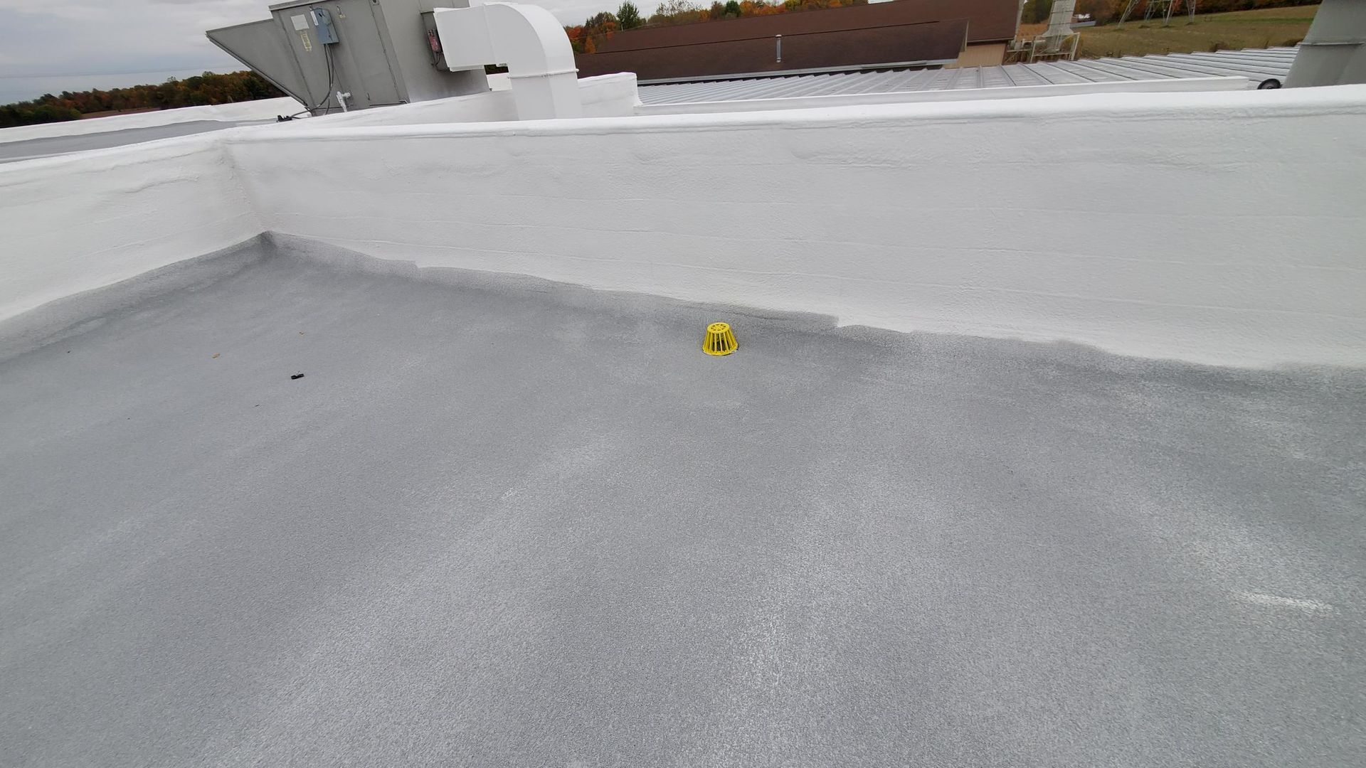 A yellow object is sitting on top of a white roof.