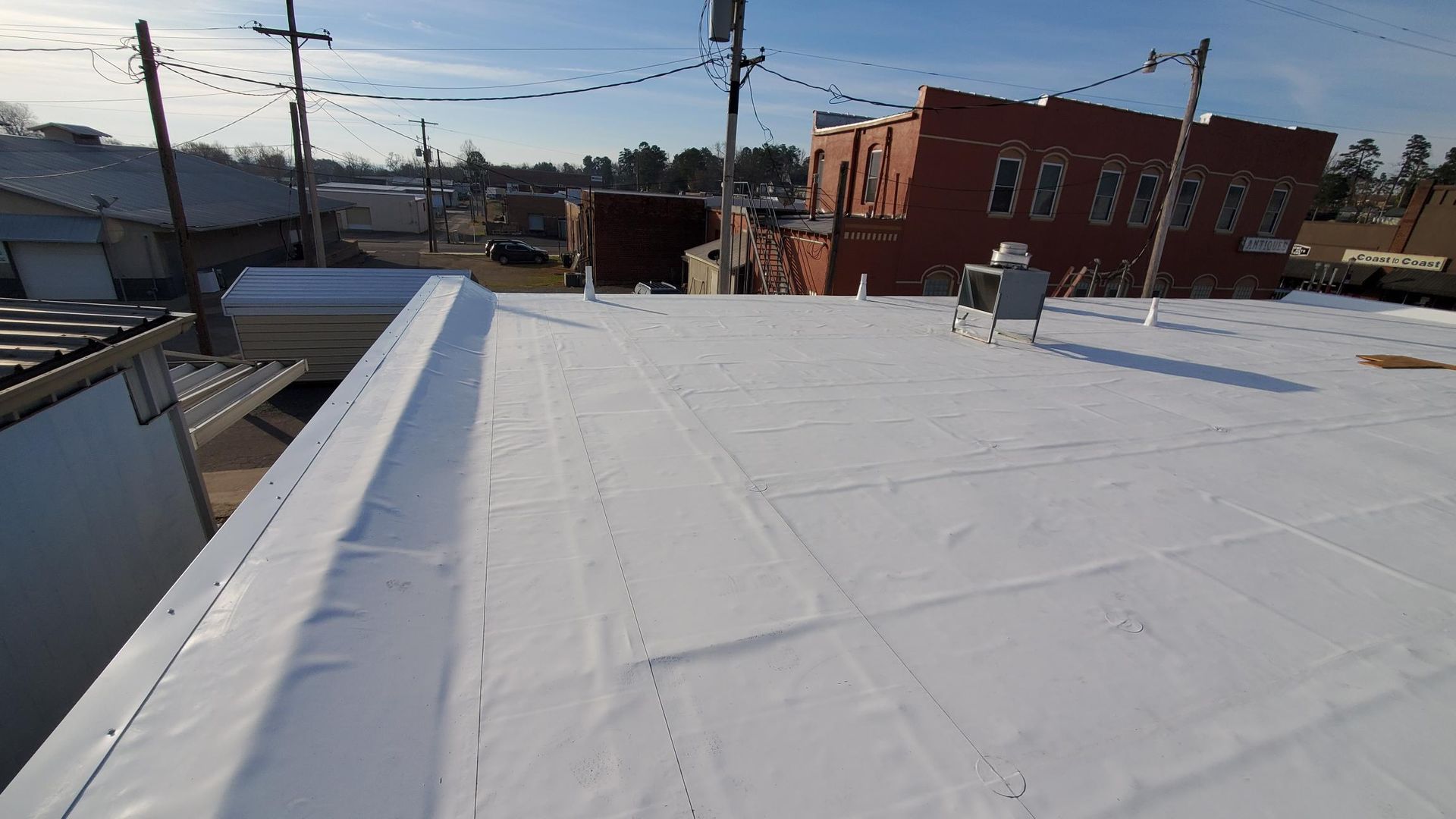 A white roof with a red building in the background