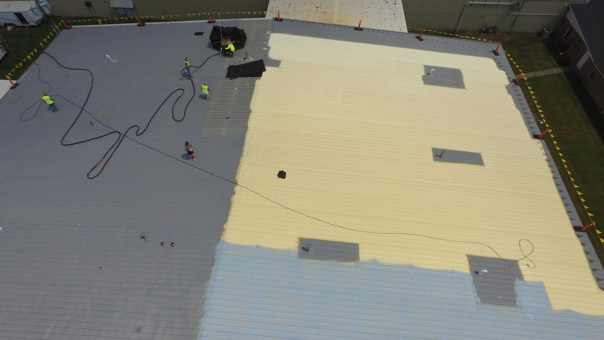 An aerial view of a roof being painted.