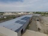 An aerial view of a large building with solar panels on the roof.