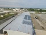 An aerial view of a building with solar panels on the roof.
