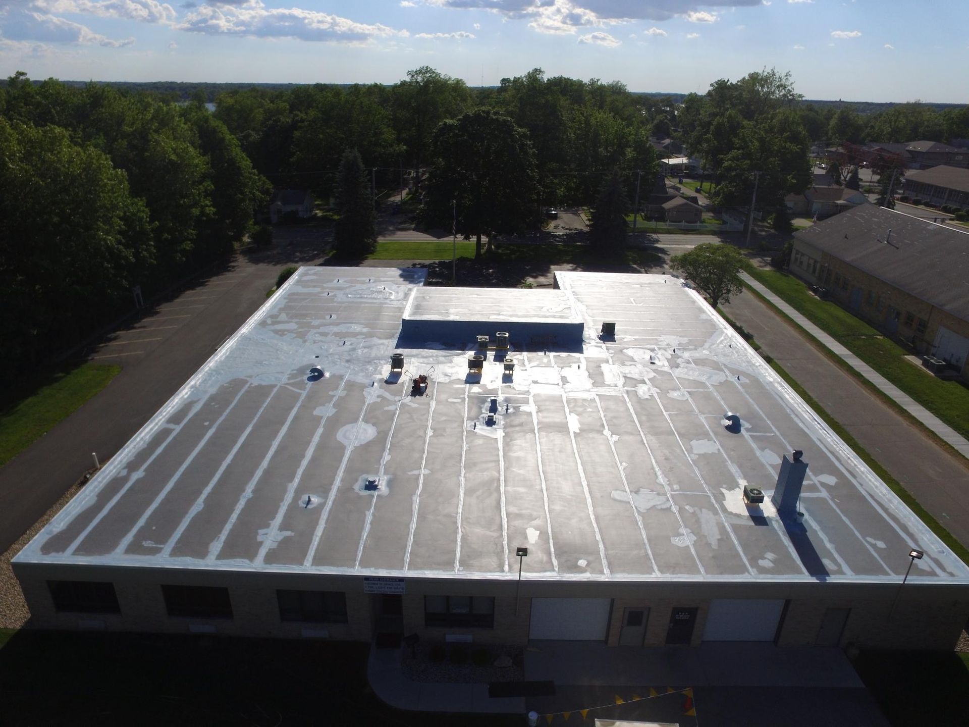 An aerial view of a roof of a building with trees in the background.