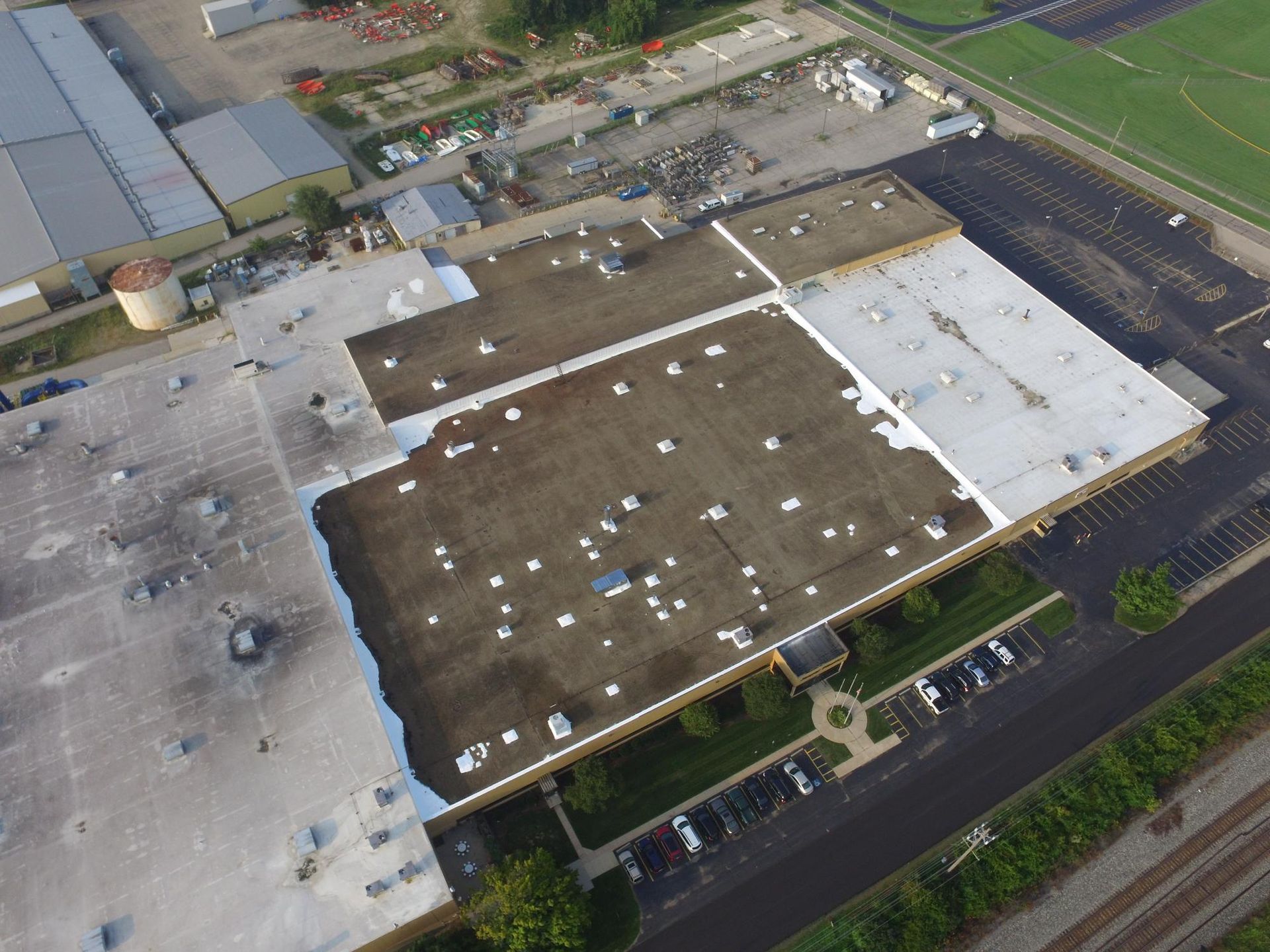 An aerial view of a large building with a parking lot in front of it.