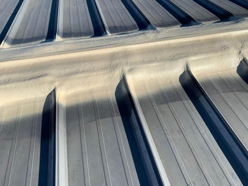 A close up of a metal roof with a drain on it.
