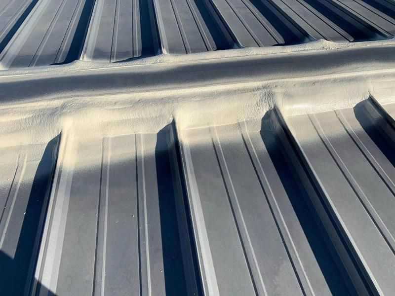 A close up of a metal roof with a drain hole in the middle.