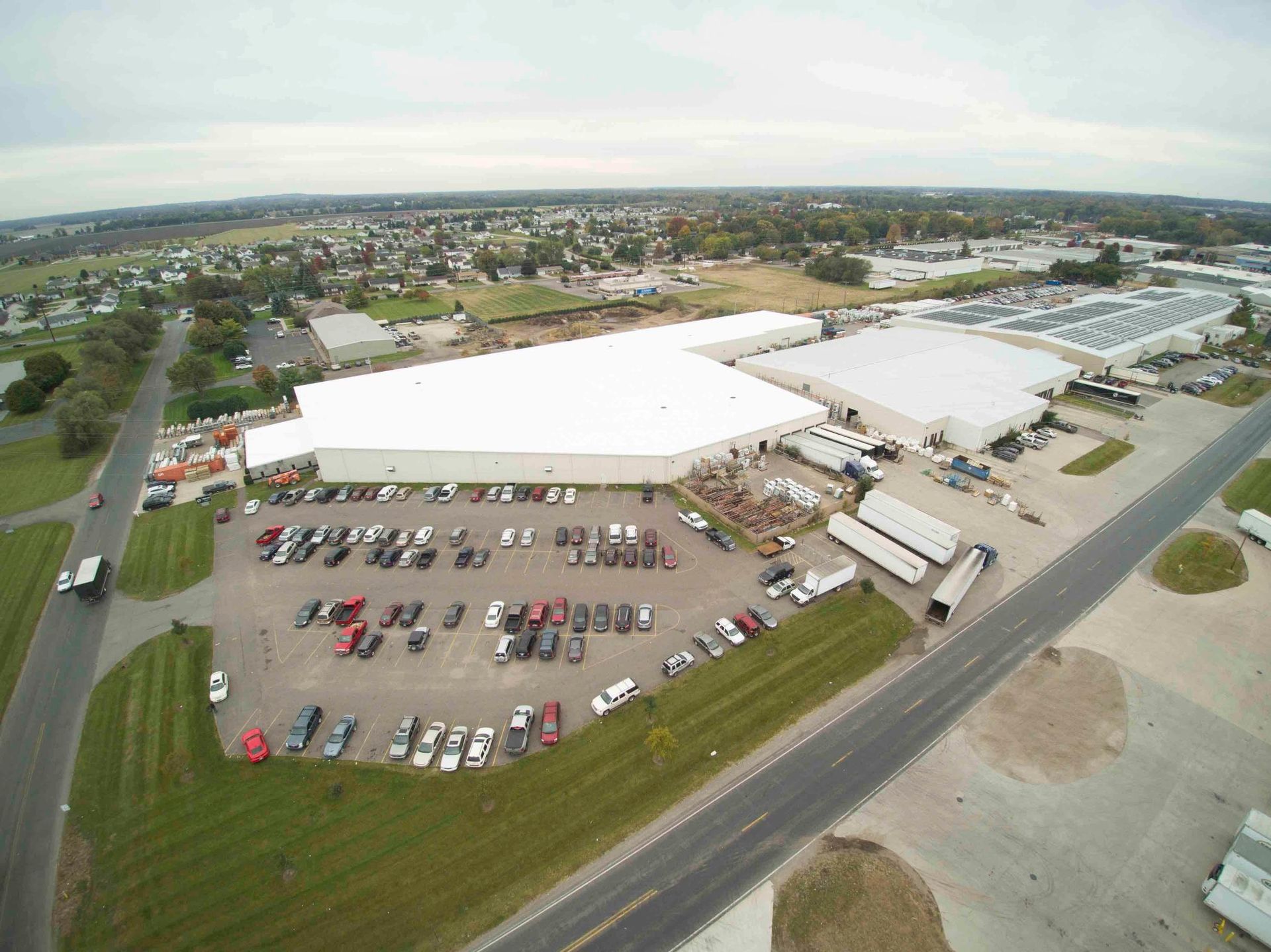 An aerial view of a large building with a lot of cars parked in front of it.