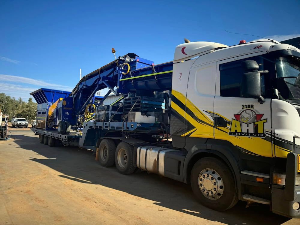 A Man Sitting At A Table Talking To A Boy In Front Of A Truck — AHT Towing in Ciccone, NT