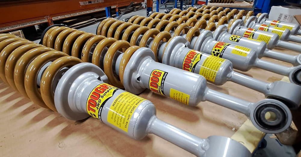 A Bunch Of Shock Absorbers Are Lined Up On A Table — AHT Towing in Ciccone, NT