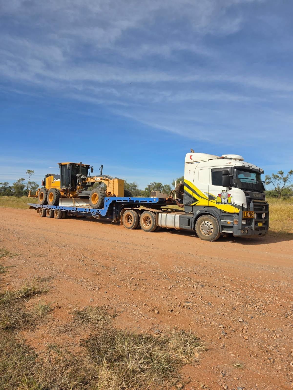 A Tow Truck With Heavy Machine On Its Back