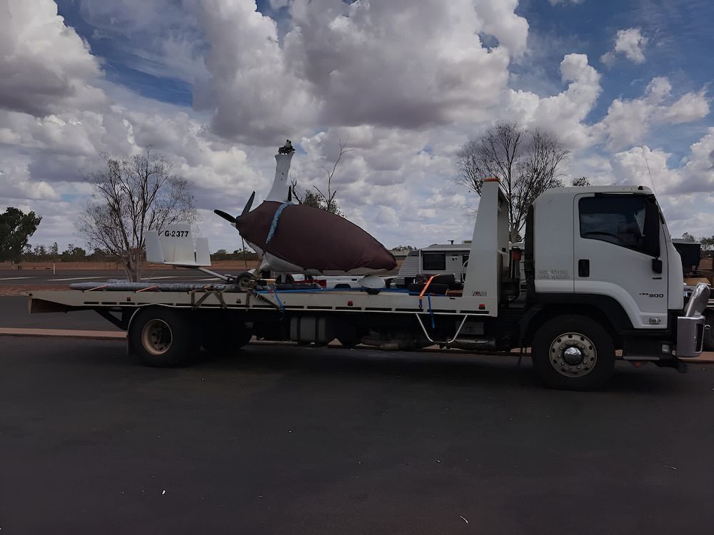 A Tow Truck With A Large Object On The Back — AHT Towing in Ciccone, NT