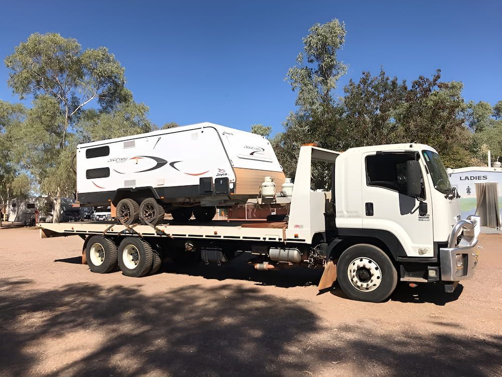 A Tow Truck Is Carrying A Caravan On A Flatbed Trailer — AHT Towing in Ciccone, NT