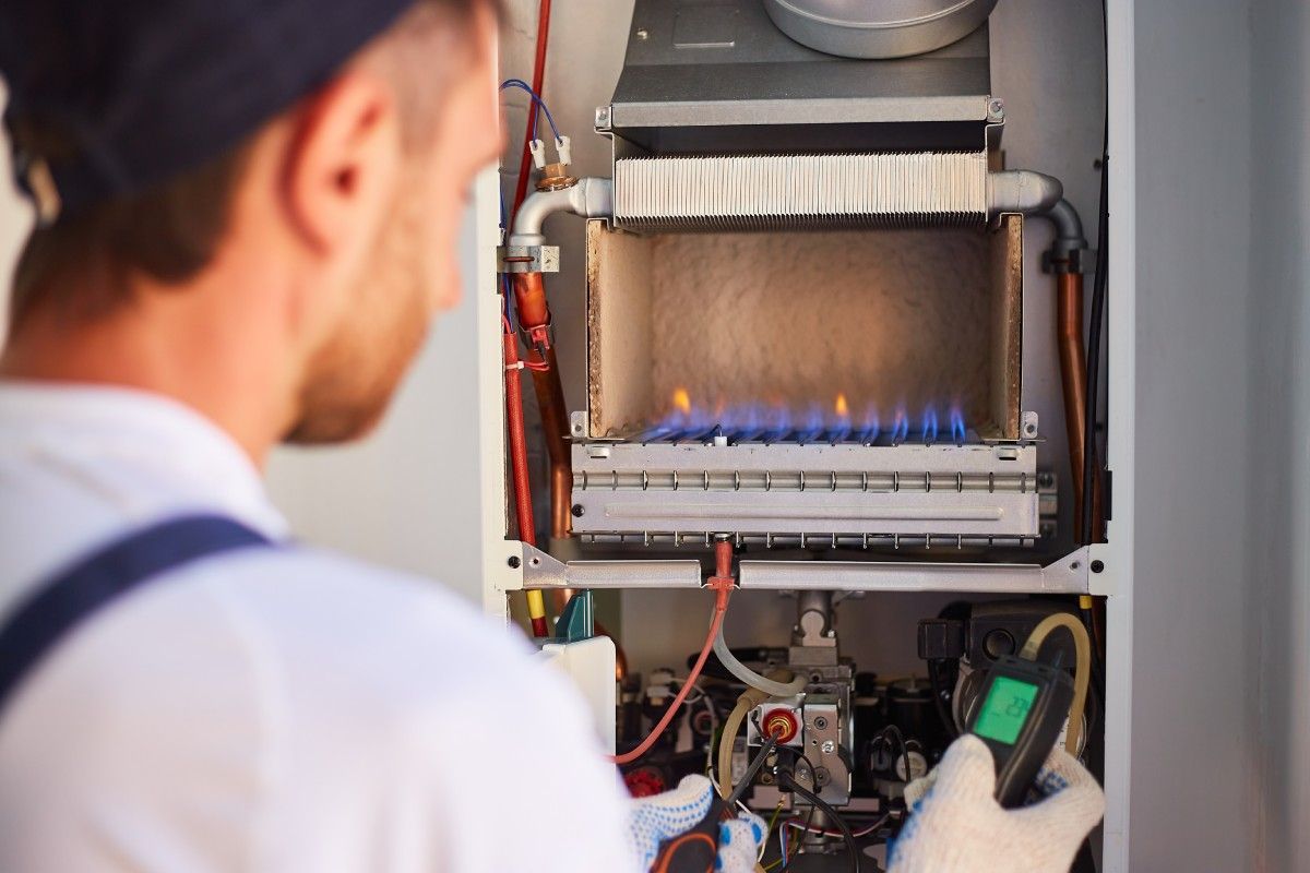 A man is working on a gas boiler.