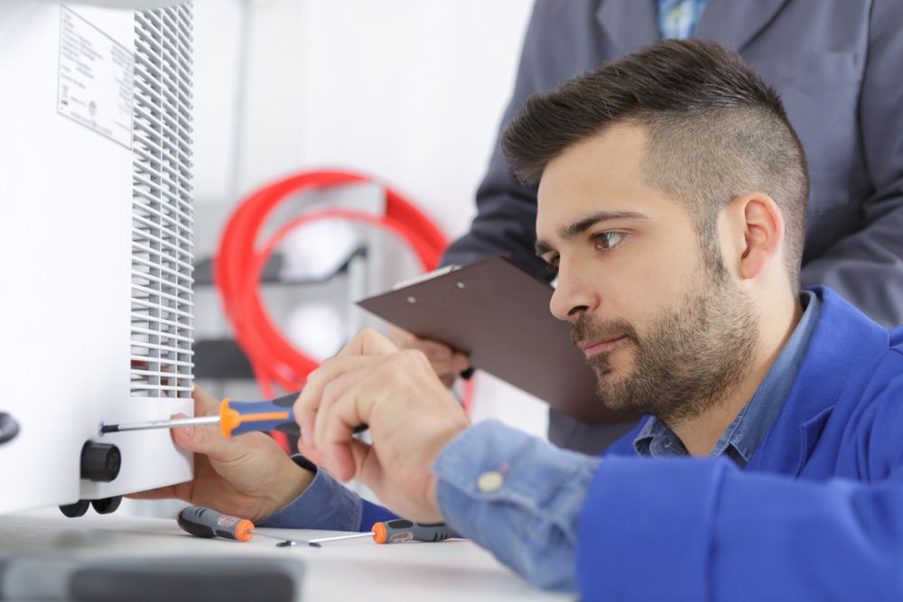A Man is Working on a Computer While Another Man Looks on — Mazlin Electrical Services Pty Ltd in Kirwan, QLD