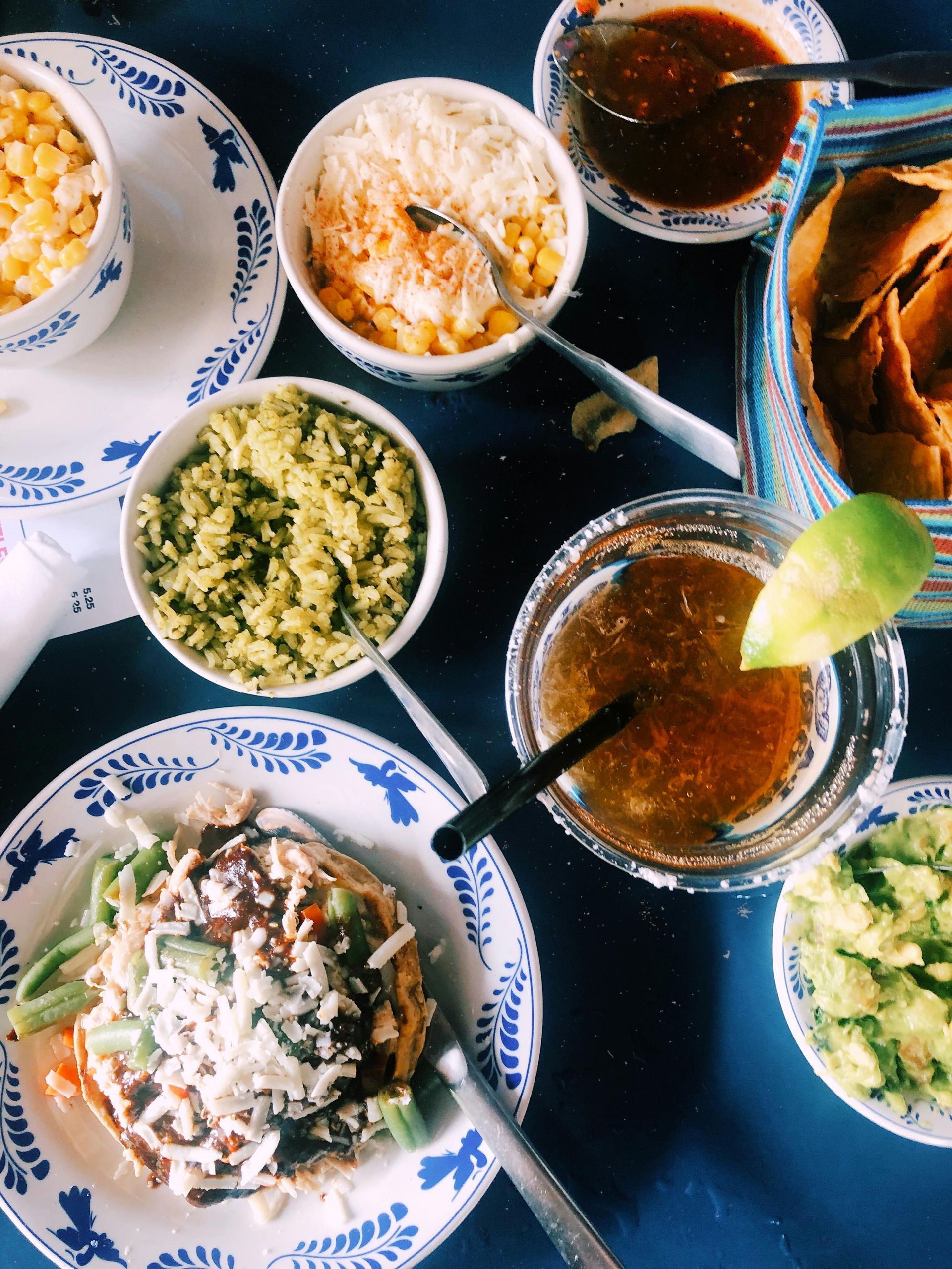 Surtido de chutneys y salsas en pequeños cuencos sobre una mesa, con rodajas de lima y papadum.