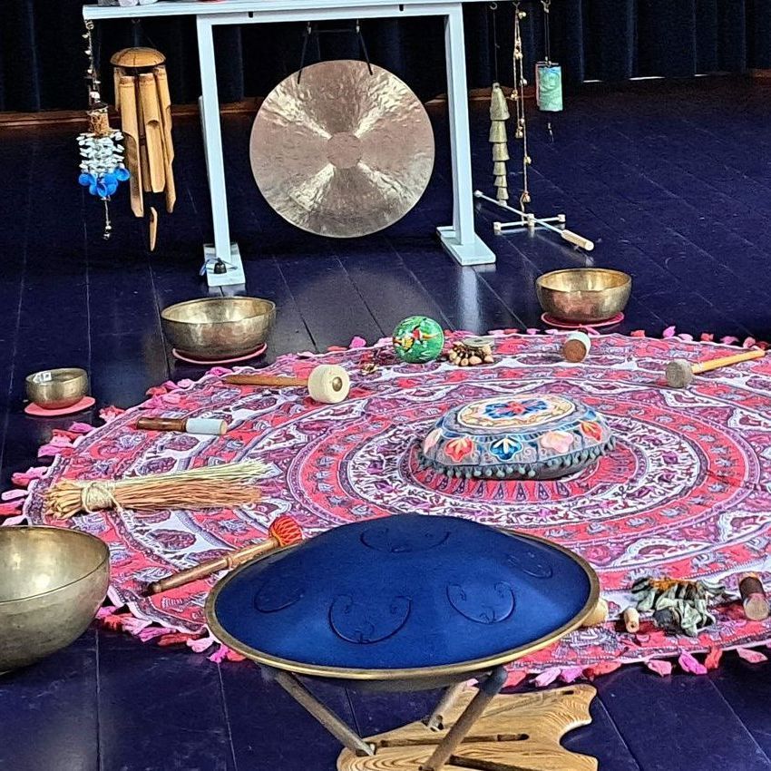 Een opstelling voor klanktherapie: een gong, klankschalen, hangdrum en percussie-instrumenten