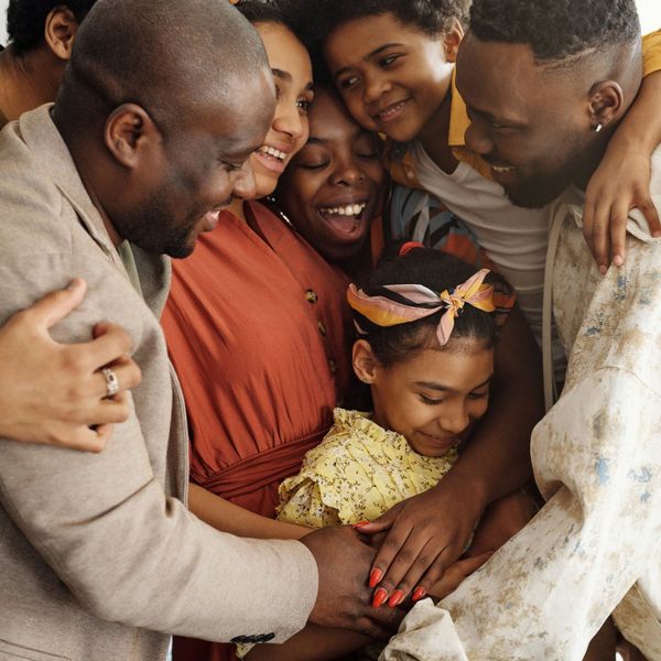 A group of people are hugging each other in a room.