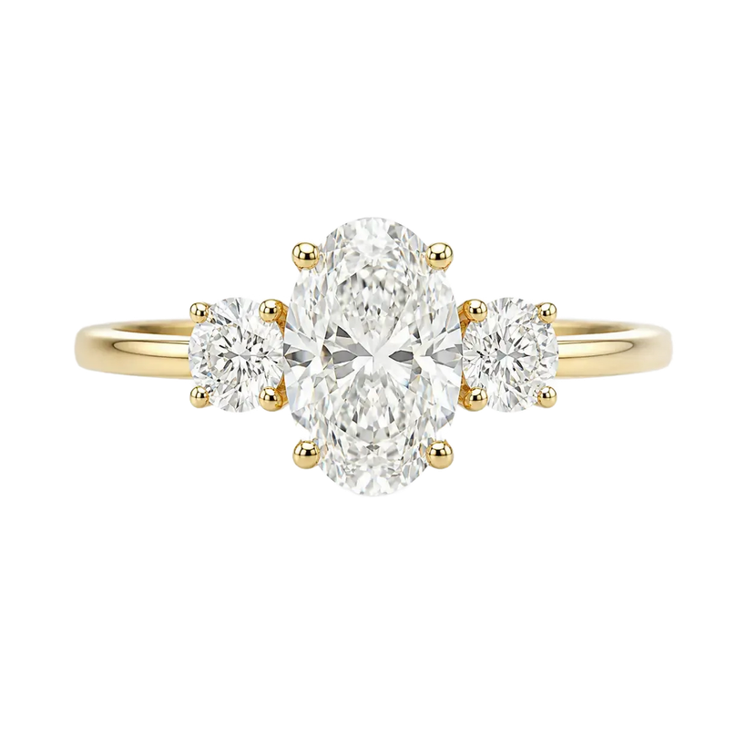 Three-stone yellow gold ring with an oval center diamond and round side diamonds.