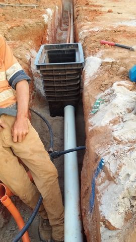 Man is Standing Next to a Pipe in a Trench — Sape Industries in Garbutt, QLD