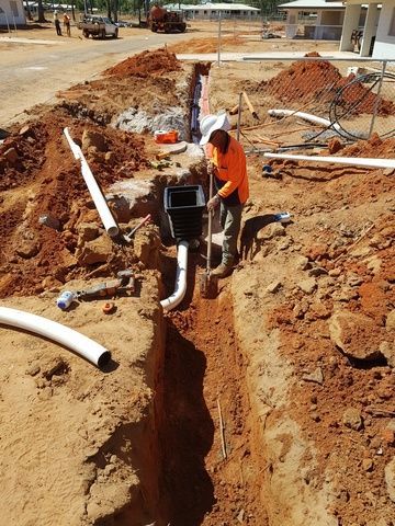 Man is Digging a Hole in the Ground to Install a Pipe — Sape Industries in Garbutt, QLD