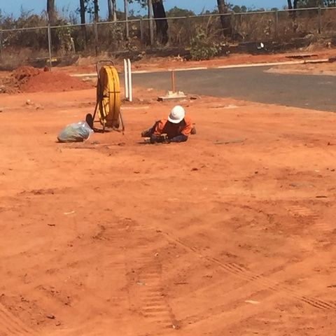 Man in a Hard Hat is Laying on the Ground — Sape Industries in Garbutt, QLD