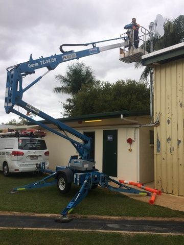 Man is Standing on Top of a Crane in Front of a Building — Sape Industries in Garbutt, QLD