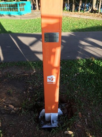 Orange Pole is Mounted in the Grass Next to a Sidewalk — Sape Industries in Garbutt, QLD