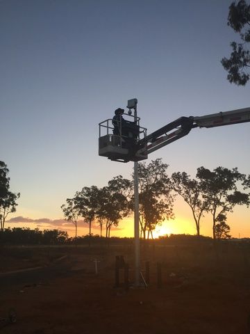 Man is Sitting in a Bucket on a Crane at Sunset — Sape Industries in Garbutt, QLD
