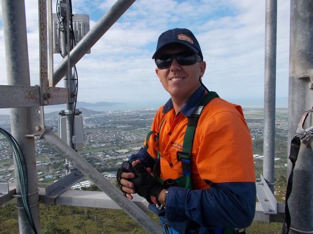 Man in an Orange Shirt is Standing on Top of a Metal Structure — Sape Industries in Garbutt, QLD