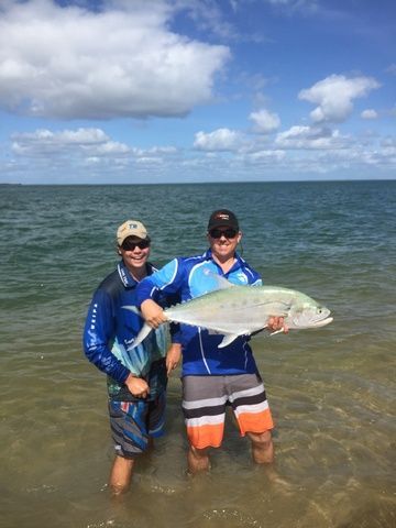Two Men Are Standing in the Water Holding a Large Fish — Sape Industries in Garbutt, QLD