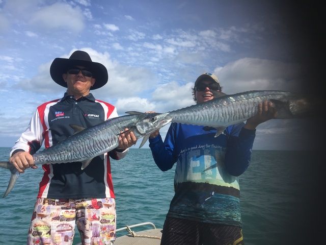 Two Men Are Standing on a Boat Holding Fish in Their Hands — Sape Industries in Garbutt, QLD