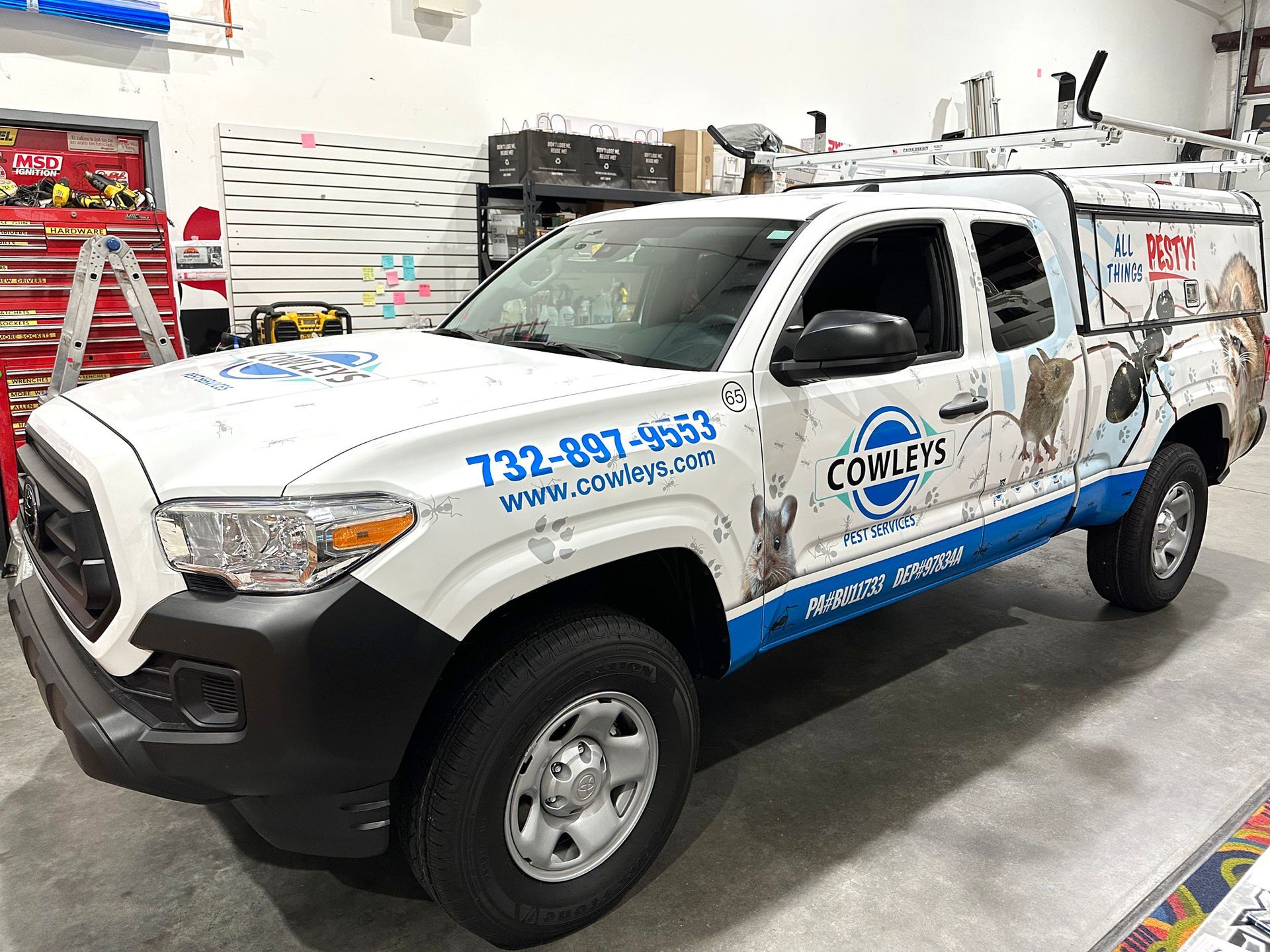 A white and blue truck is parked in a garage.