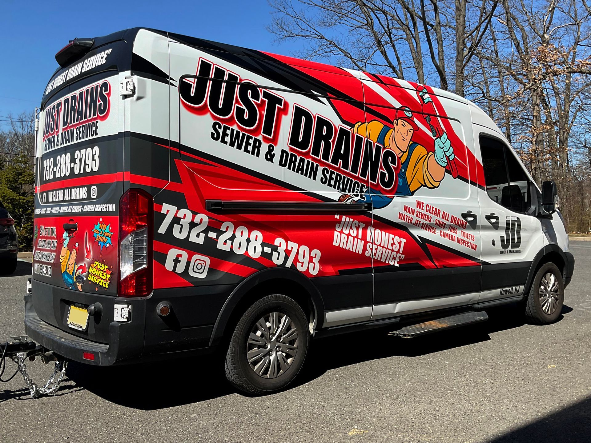 A just drains van is parked on the side of the road.
