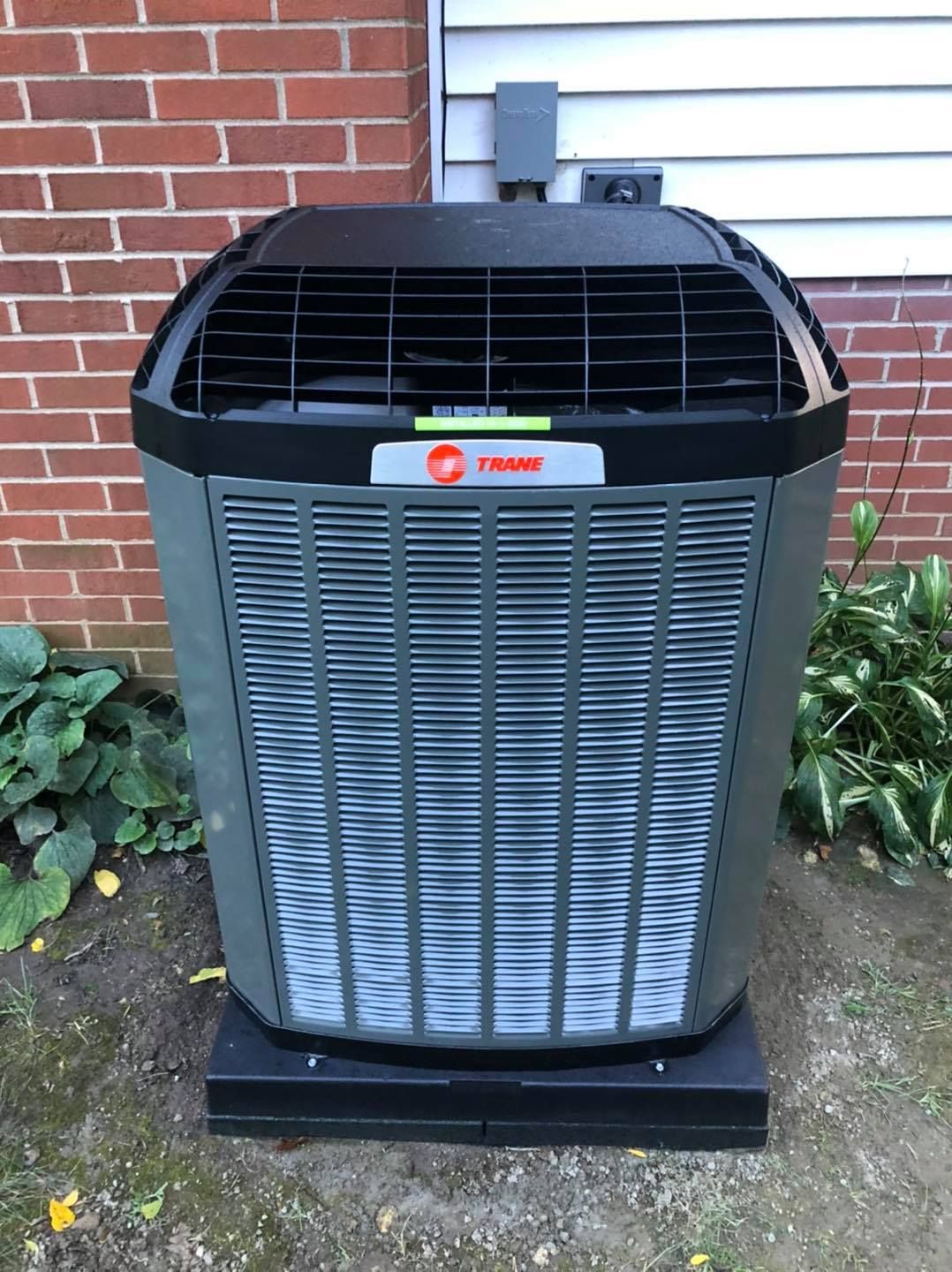 Trane air conditioning unit outside a brick building.