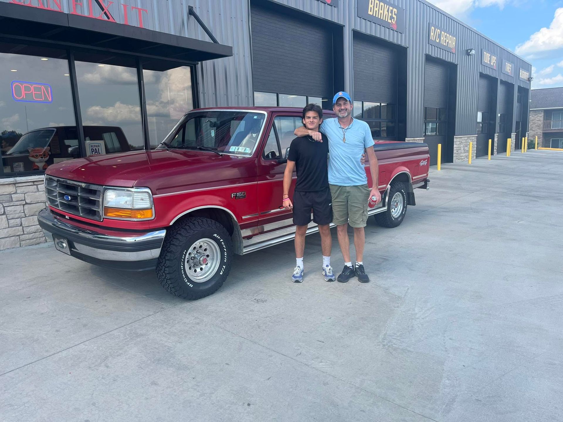 Customers Standing Beside Red Pickup Truck At Auto Repair Shop | Fox Total Car Care LLC