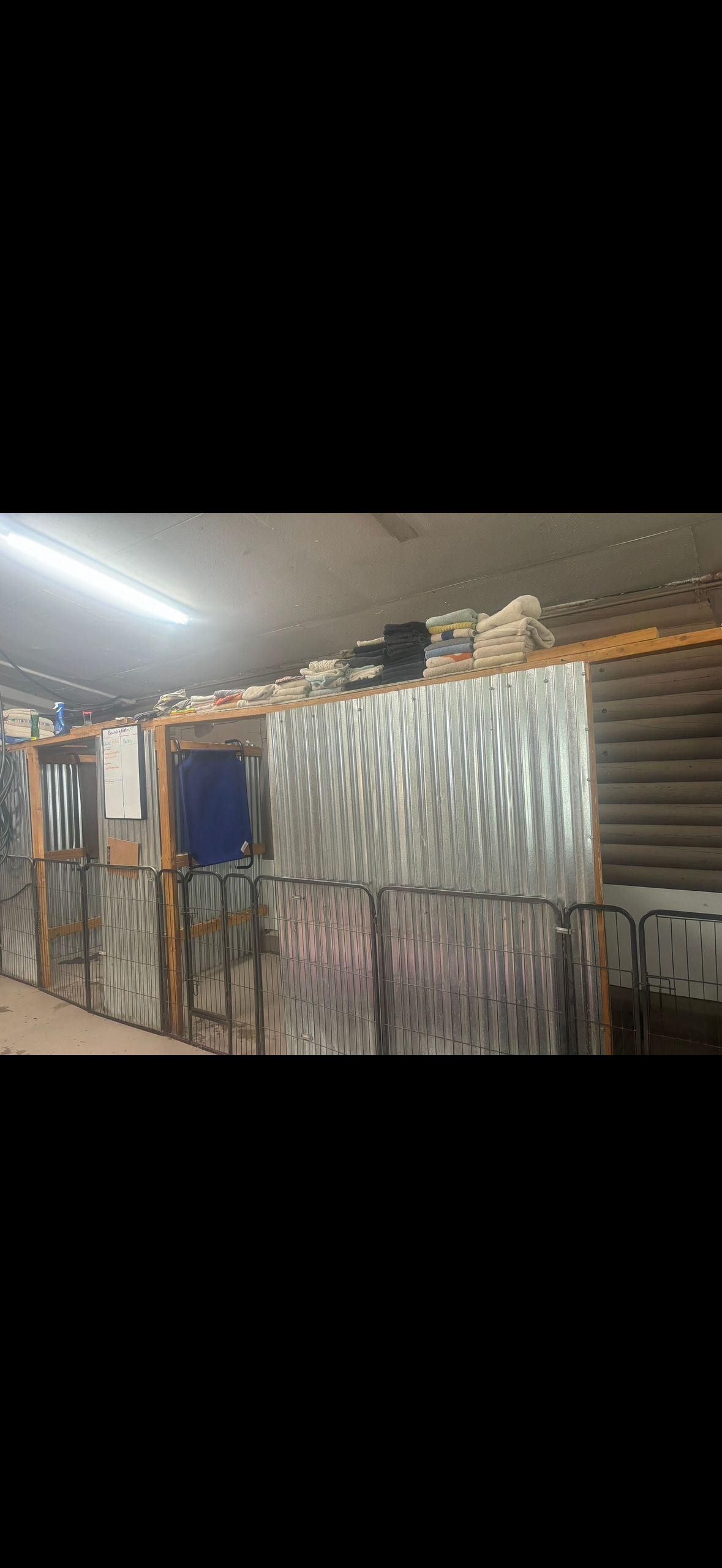 Interior of a warehouse, featuring corrugated metal walls and stacked materials.