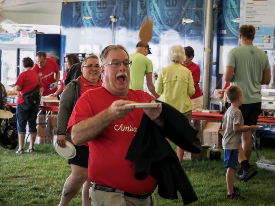 John Roth is holding a plate in his hand.
