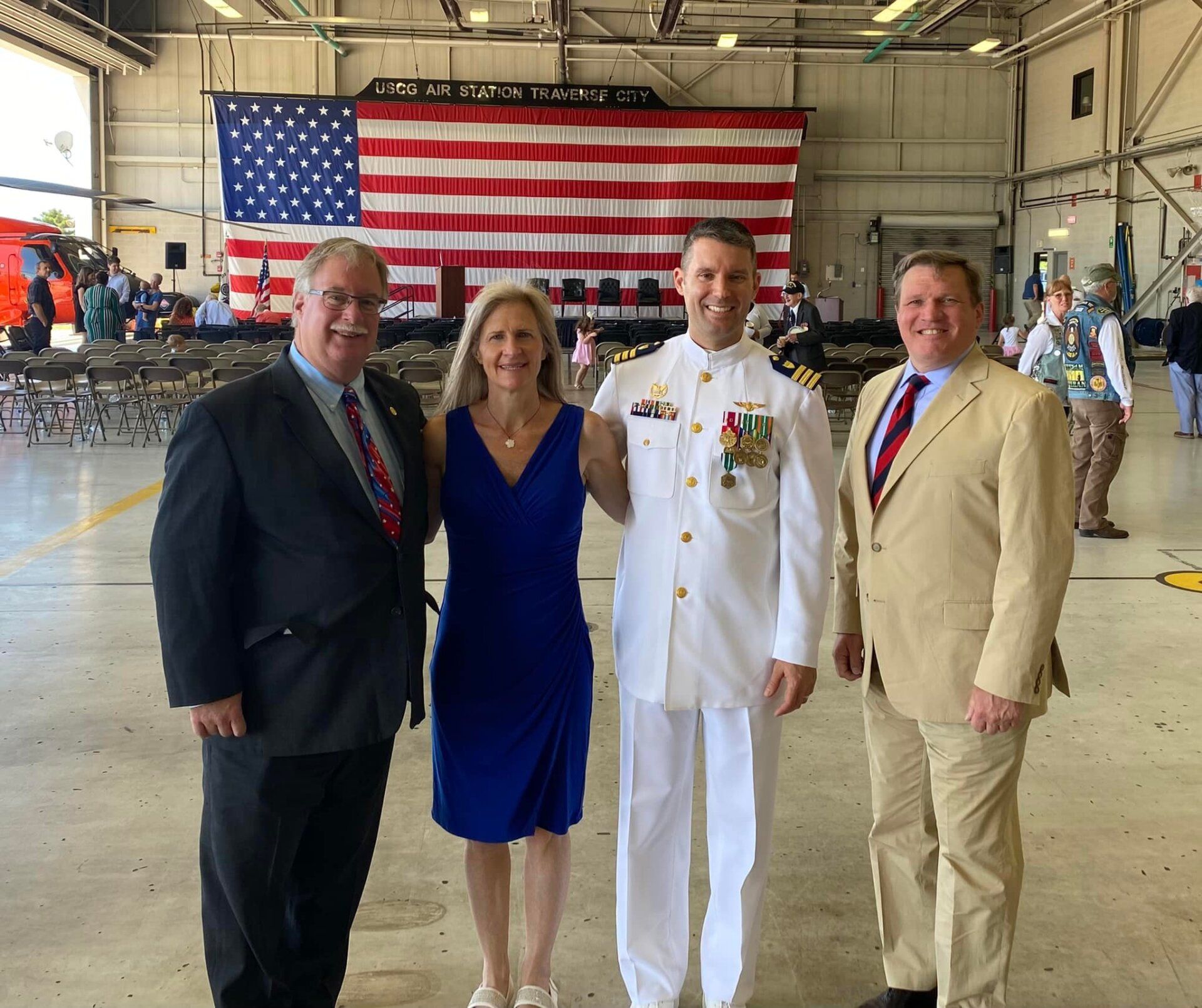 A group of people posing for a picture in front of an american flag with john roth