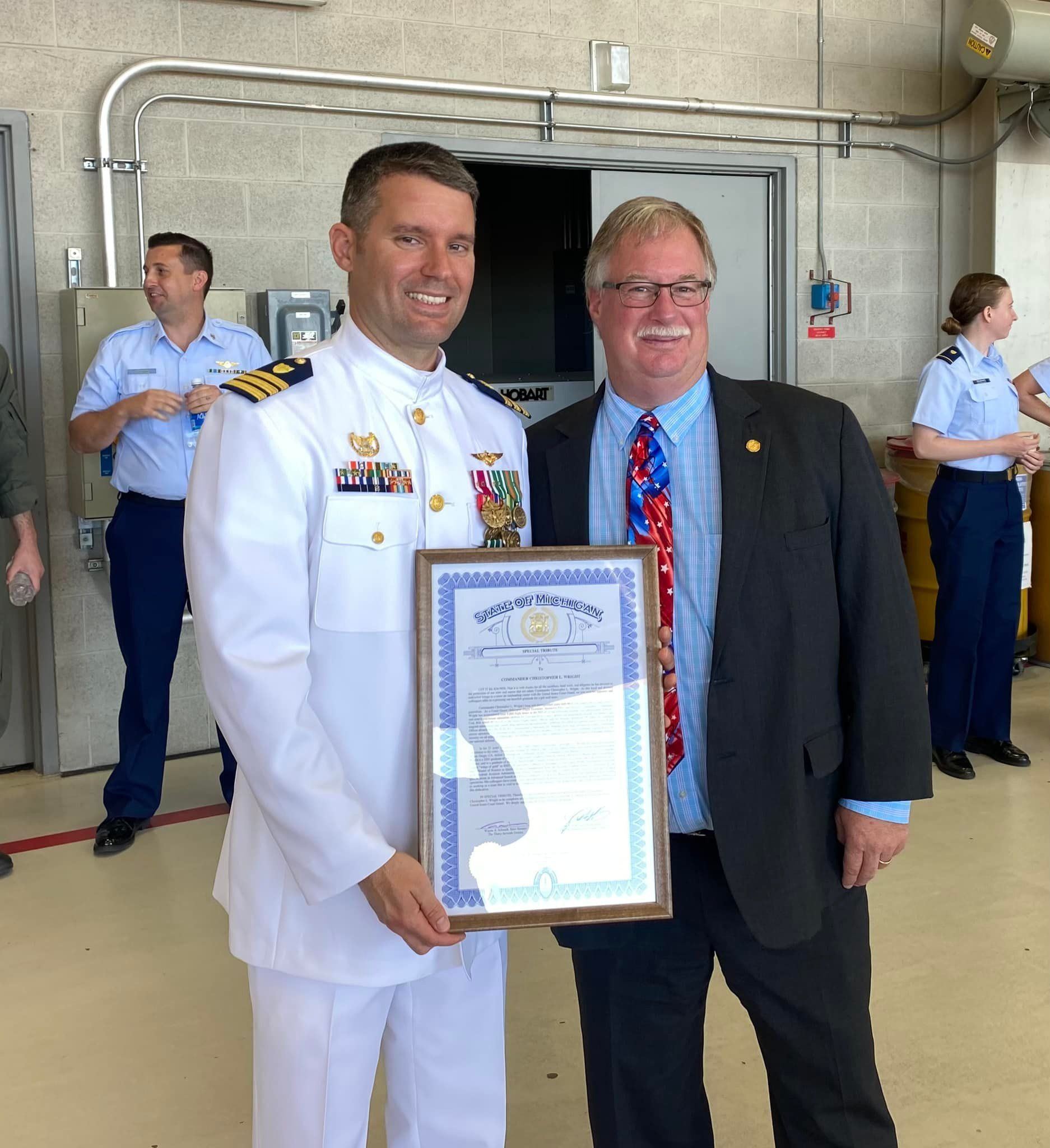 John Roth -  and man in military uniform is holding a framed certificate