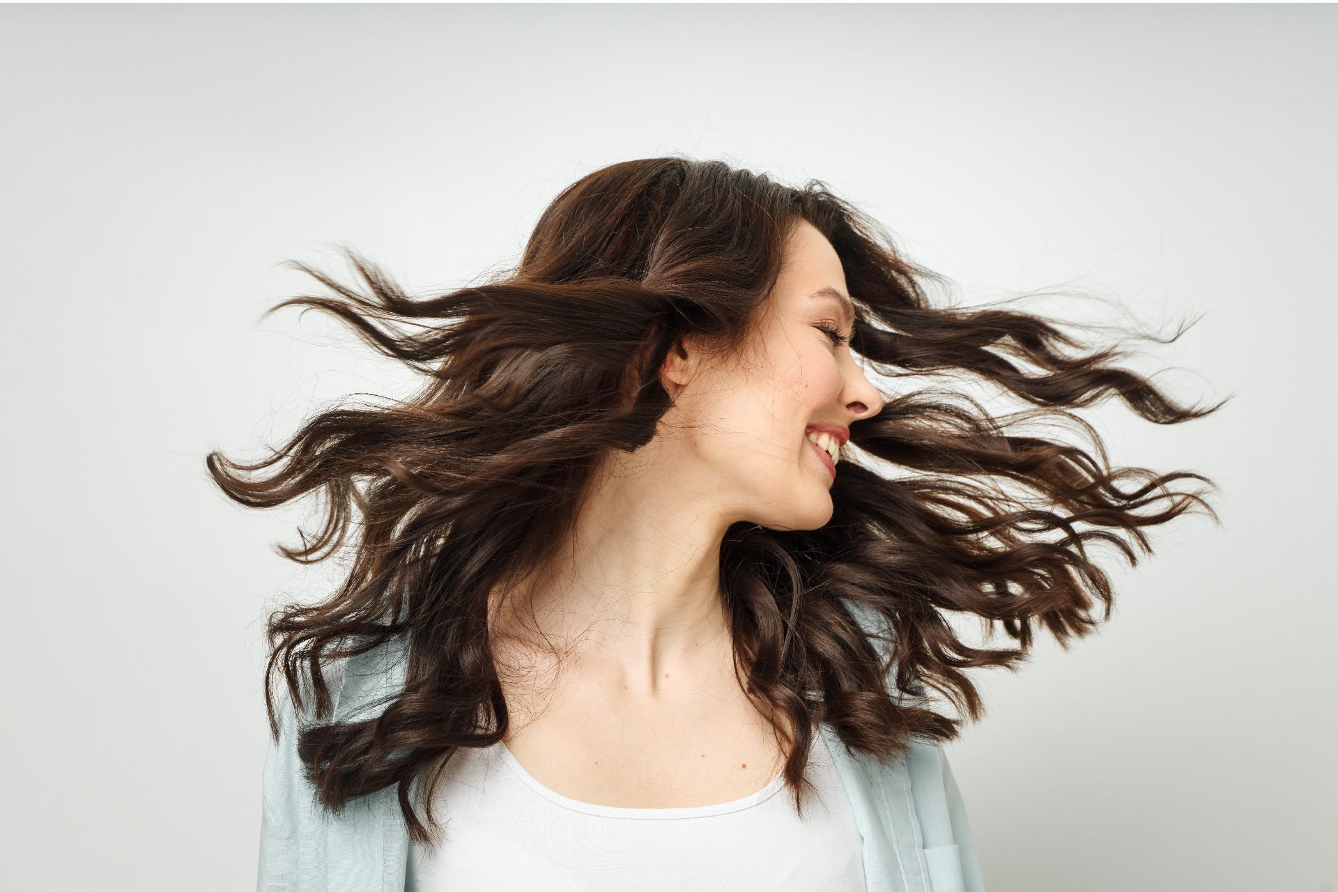 Una mujer con cabello largo y castaño ondea en el viento.