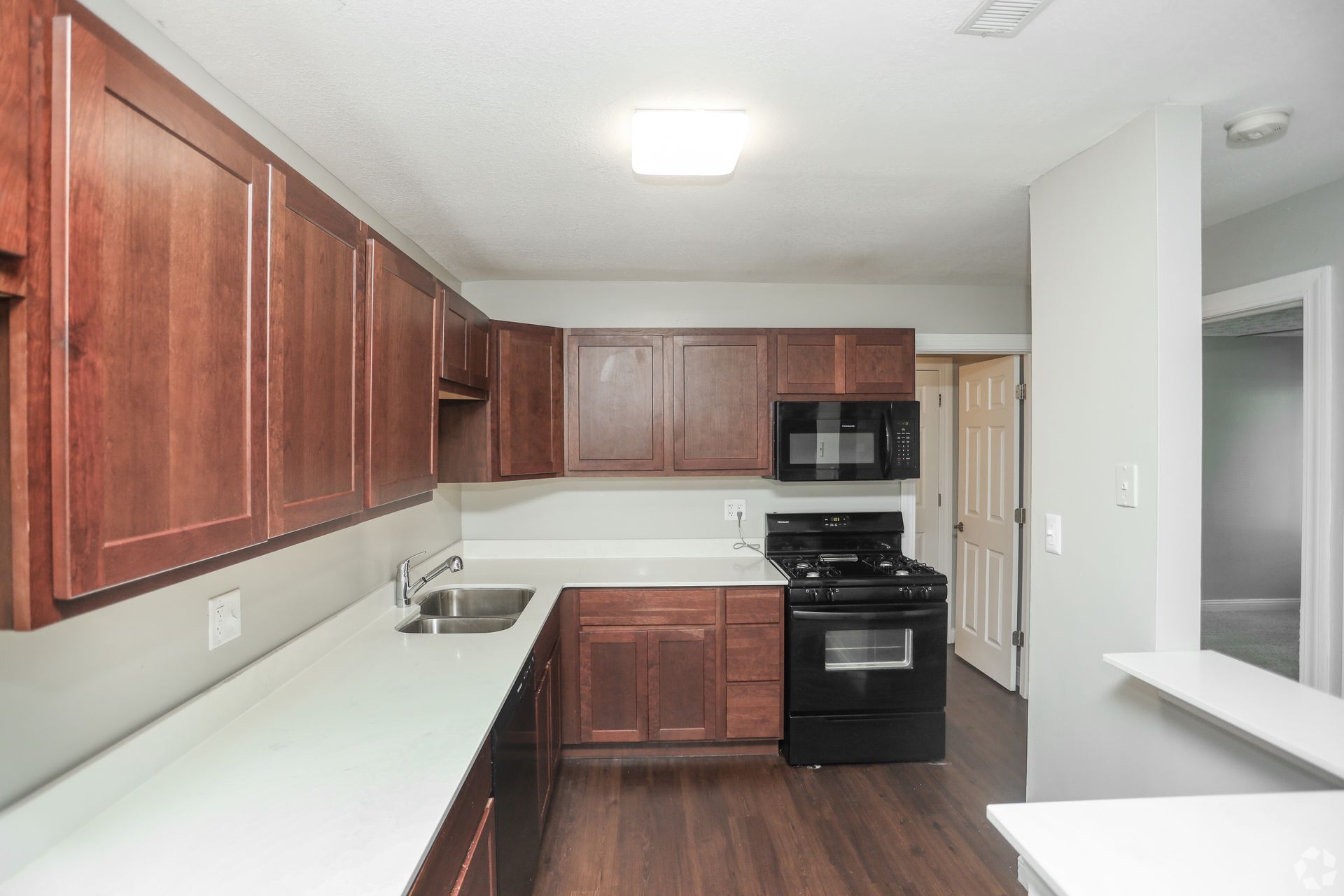Garden Pointe kitchen with brown cabinets, a fridge, and a dishwasher