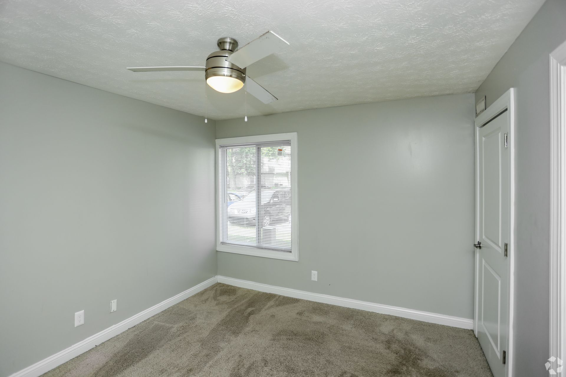 Carpeted bedroom with window and fan