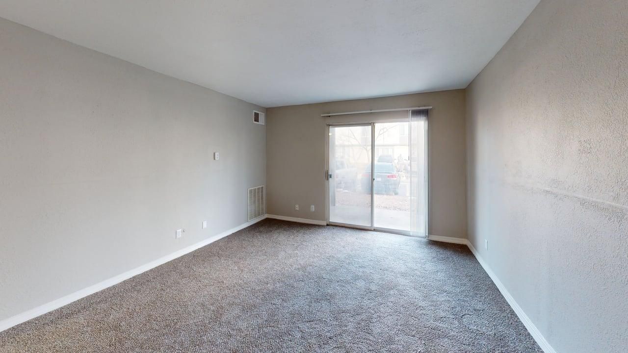Living room with sliding glass door and carpeting