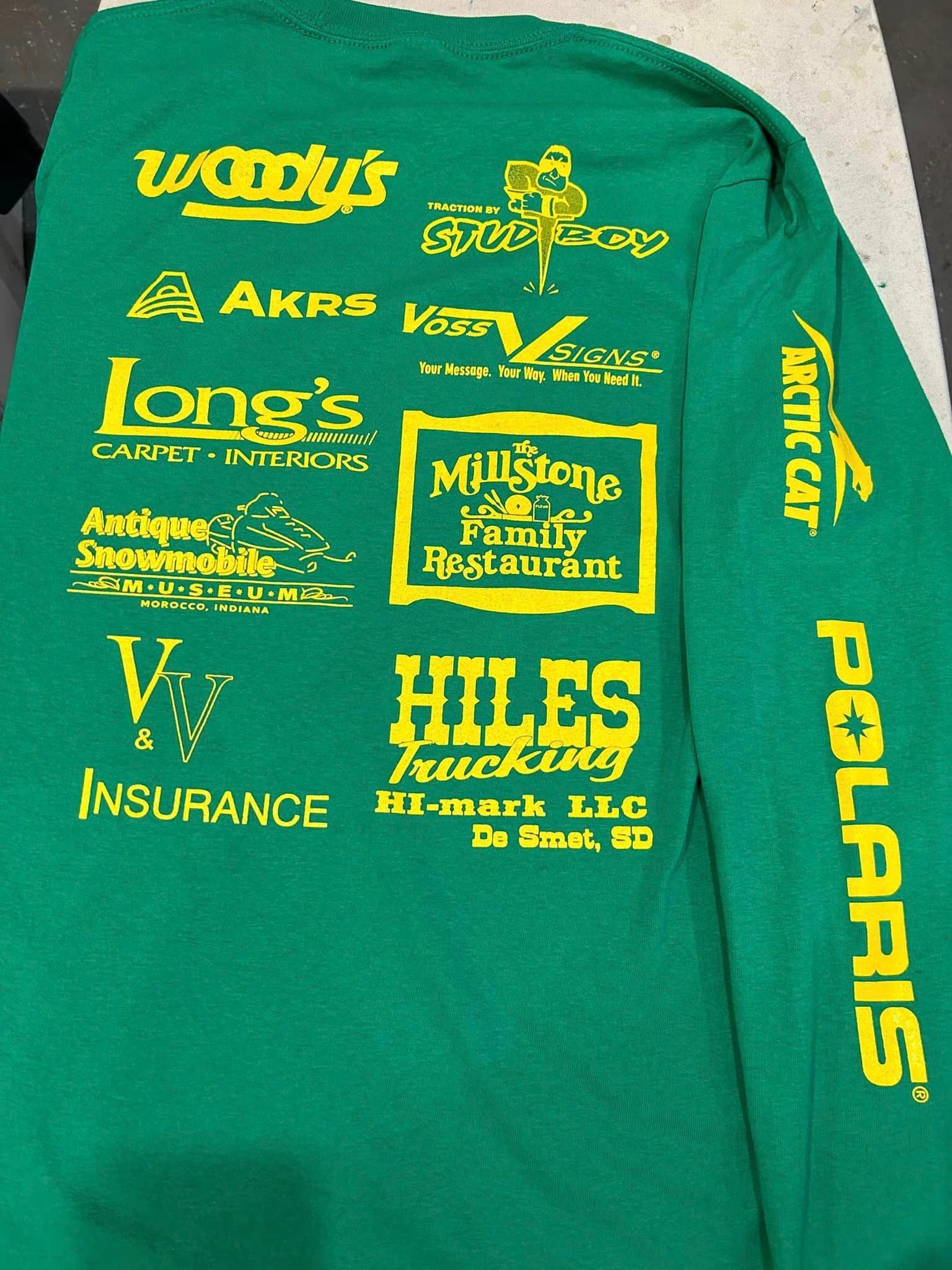 A green long-sleeve shirt back with rows of yellow sponsor logos and the word